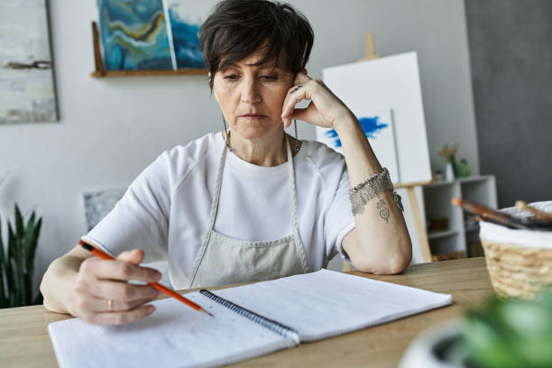 istock Creative senior woman immersed in her painting process in a bright studio space 2188018652