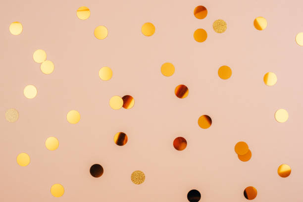istock Golden confetti scattered on a soft beige background, top view 2188018984