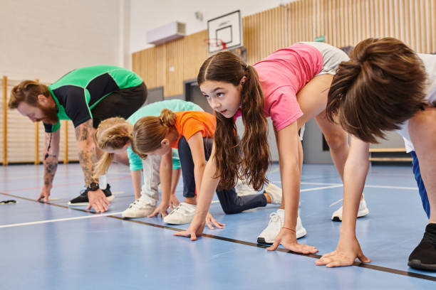 Engaging teacher guides pupils in a fun and competitive sprinting exercise during gym class