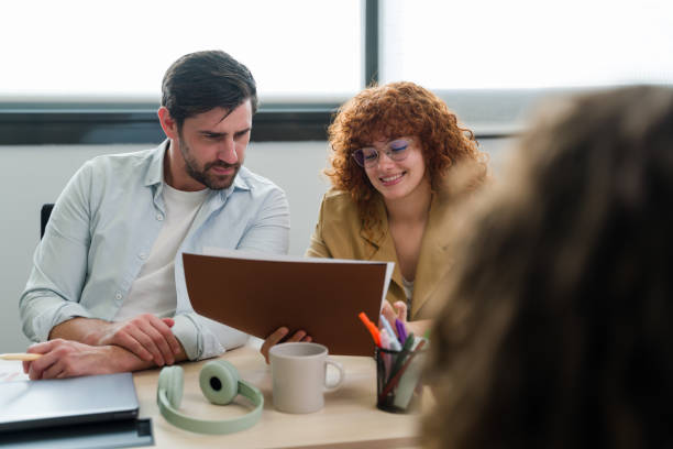 istock businesspeople reading a document together at office desk 2188021068