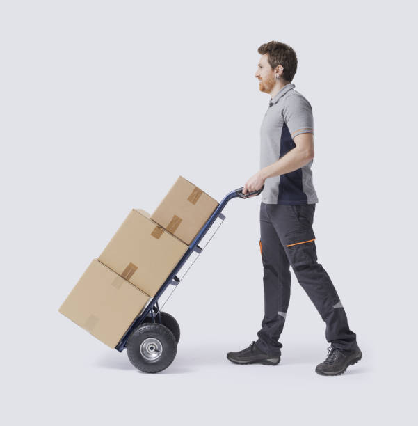 istock Warehouse worker pushing a hand truck 2188023613