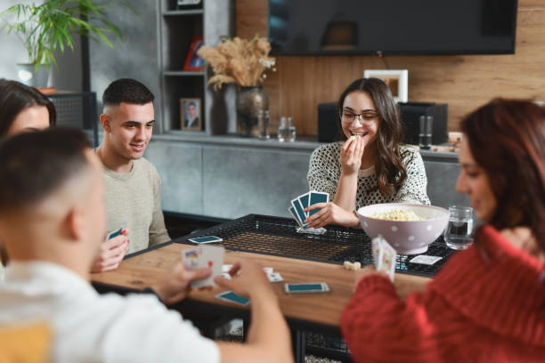 istock Female Player Eating Popcorn While Waiting for Her Turn in Card Game 2188024113