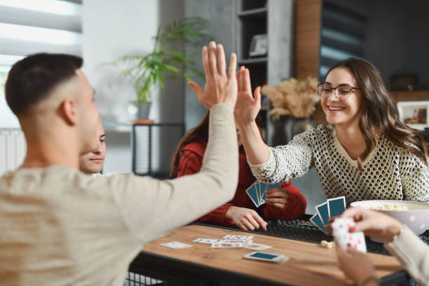 istock Joyful Siblings Winning in Card Game Giving Each Other High Five Over Table 2188024263