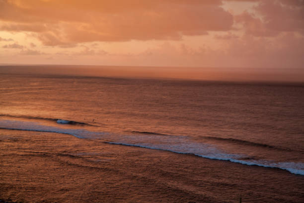 Vast shot of a sunset with mountains and water near, the sky behind. Taken in Kauai, Hawaii, during the day.