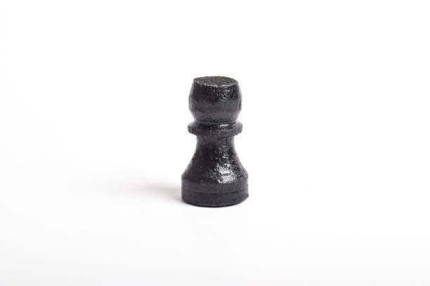Group of white chess pawns surrounding a single black pawn as a concept of racism and discrimination.