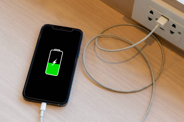 istock hand holding smart phone connecting with electric power for recharge 2188029293