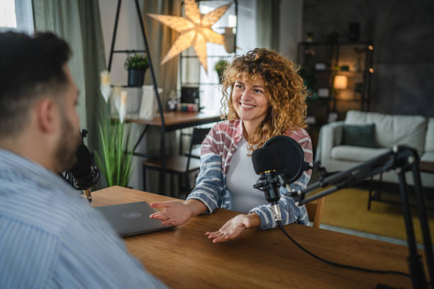istock woman host interviewer ask man guest questions while record podcast 2188032017