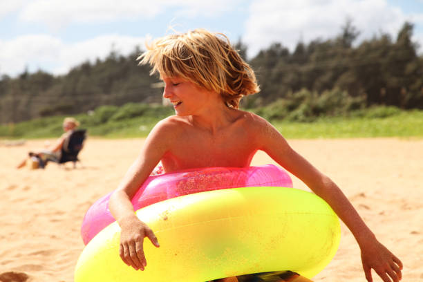 Unrecognizable girl holding purple ball at the beach at summer