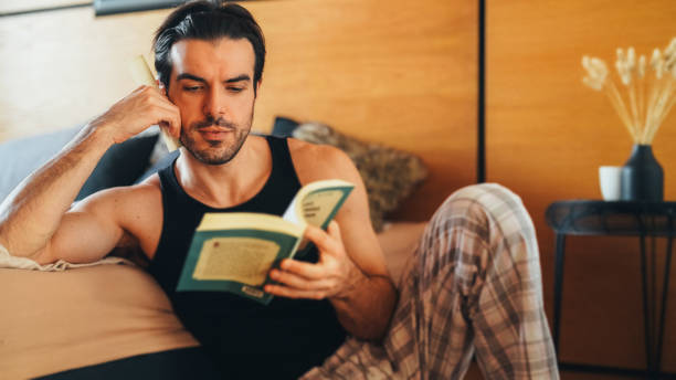 istock Man reading a book in the bedroom 2188034567