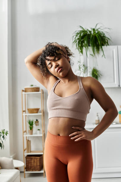 istock Young Black woman stretching in her modern apartment during a home workout 2188036792