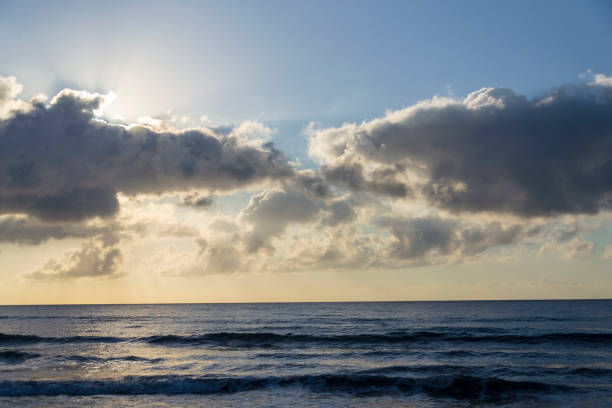 istock Breathtaking sunrise with sun hiding behind cloud, sea waves and blue sky with copy space 2188038312