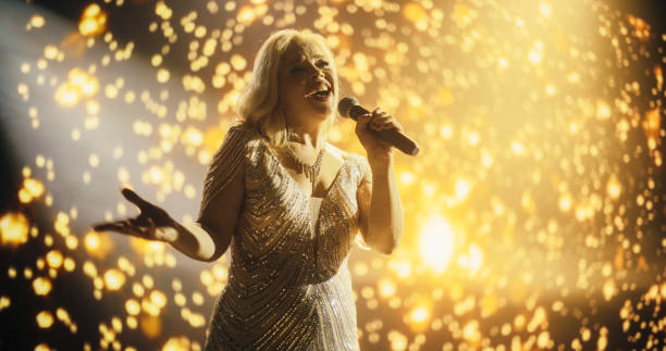 istock Female Singer Using Her Powerful Voice to Perform Iconic Pop Songs for Admiring Audience. Music Concert with a Beautiful Solo Act. Colorful Stage Visuals in the Background 2188040883