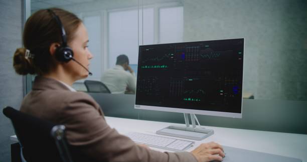 istock Female stockbroker talks on headset, analyzes financial charts and diagrams on computer 2188041374