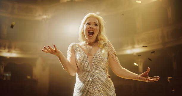 istock Classical Lead Singer Performing in Front of an Audience in a Theater, Watching a Powerful Music Show by a Talented Anonymous Female Opera Star. Mesmerizing Confetti Falling on Stage 2188041838