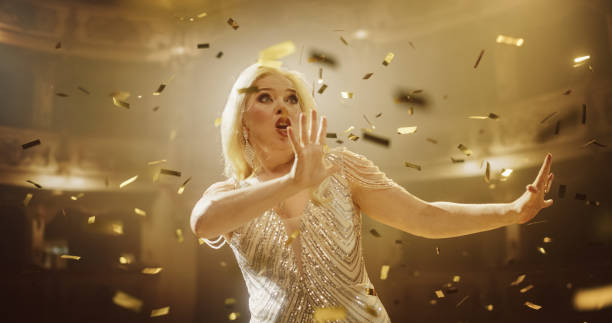 istock Classical Lead Singer Performs with a Mix of Emotions and Energy. Audience Sitting in a Theater, Watching a Powerful Music Show by a Talented Female Opera Star. Mesmerizing Confetti Falling on Stage 2188041852