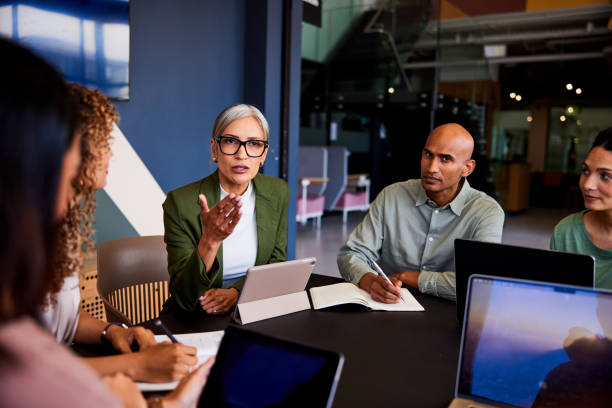 istock Confident female manager wearing glasses in team meeting, gesturing and explaining 2188043456