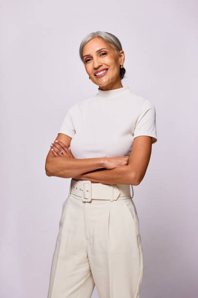 Portrait of confident mature woman looking at camera, arms folded stock photo