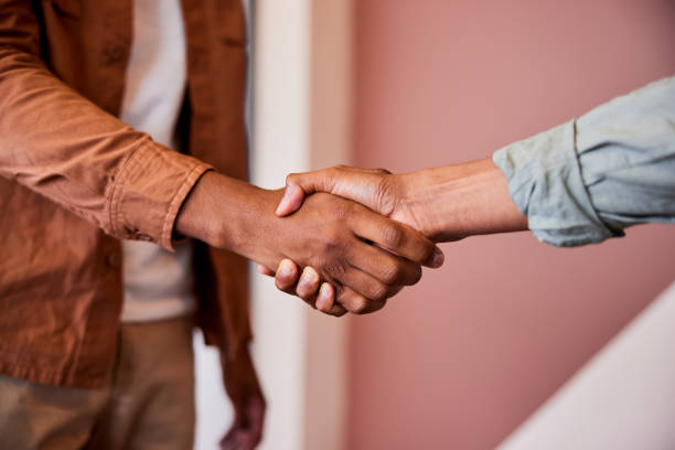 istock Two businessmen shaking hands, close up 2188043576
