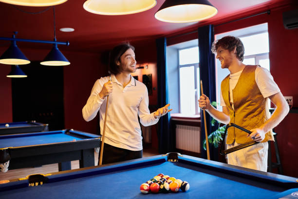 istock Friends share laughter and skill while enjoying a game of billiards indoors 2188044730