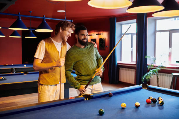 istock Two multicultural friends enjoy a spirited game of billiards in a vibrant pool hall setting 2188044785