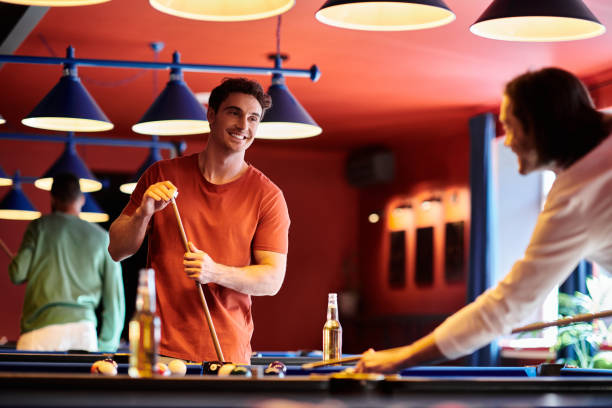 istock Friends enjoy a lively evening playing billiards at a cozy pool hall 2188045107