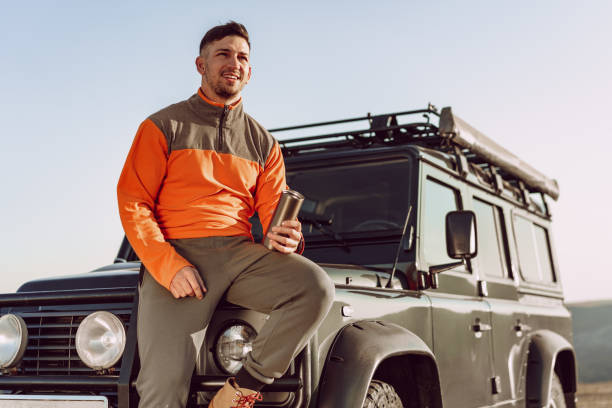 istock Young man traveler drinking from his thermocup while halt on a hike 2188045252