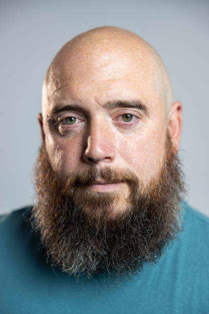 Close-up studio portrait of a mature male model looking into the camera with a blank expression on his face, wearing a T-shirt. Located in Newcastle, North East England.