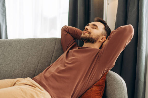 istock Smiling, handsome Hispanic man relaxing, lying on comfortable sofa in cozy home. Resting concept 2188046630