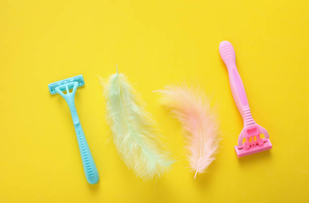 istock Depilatory razors with feathers on yellow background 2188046789