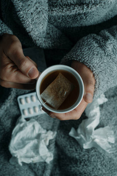 istock ill man at home warming up with a herbal tea 2188047004