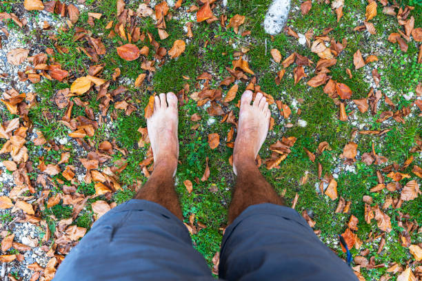 Perspective view of a person hiking barefoot in nature