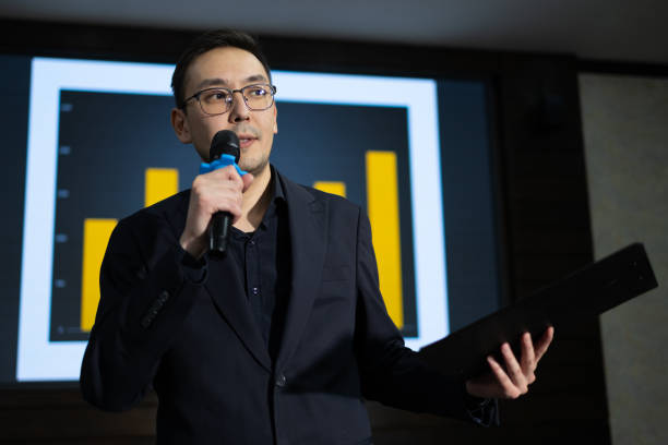 istock Speaker presents data insights at a business conference in a modern setting 2188052586