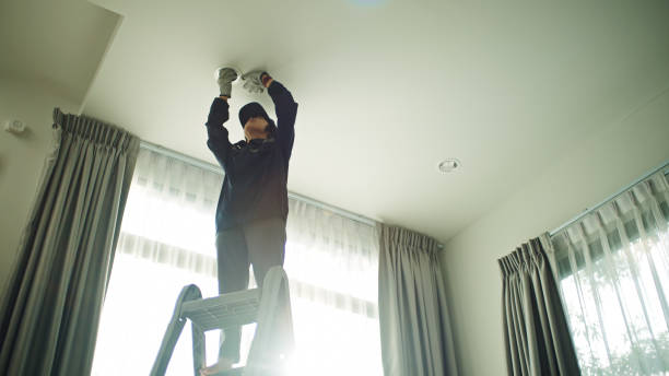 istock Electrician woman changing light bulb. 2188058726