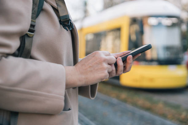 Woman using smartphone while waiting for public transport