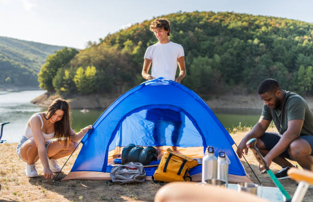 istock Young friends setting up a tent by the lake 2188066079