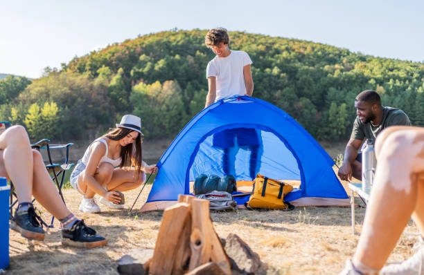 istock Young friends setting up a tent by the lake 2188066310