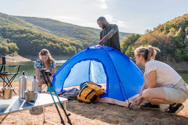 istock Young friends setting up a tent by the lake 2188066490