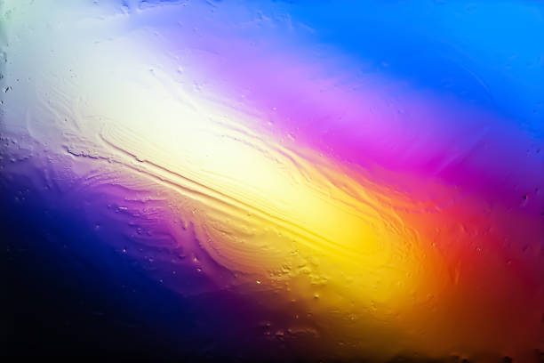 Blurred abstract background. Abstract image of multi-colored blurry spots and glare through wet glass. Texture of traces of water and oil on glass. Creative background