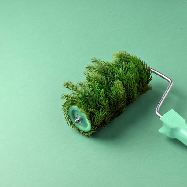 istock Paint roller covered with fir branches on a green background. A creative and unconventional concept combining nature and creativity, creating a fresh festive atmosphere. 2188071609