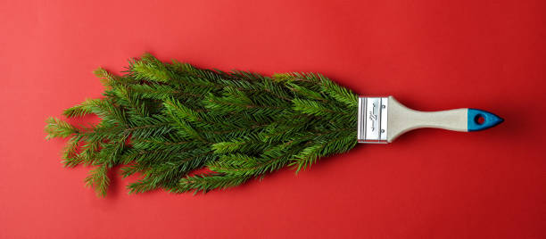istock Creative Christmas banner featuring a paintbrush covered in pine branches on a red background. Ideal for festive promotions and holiday campaigns. 2188071614