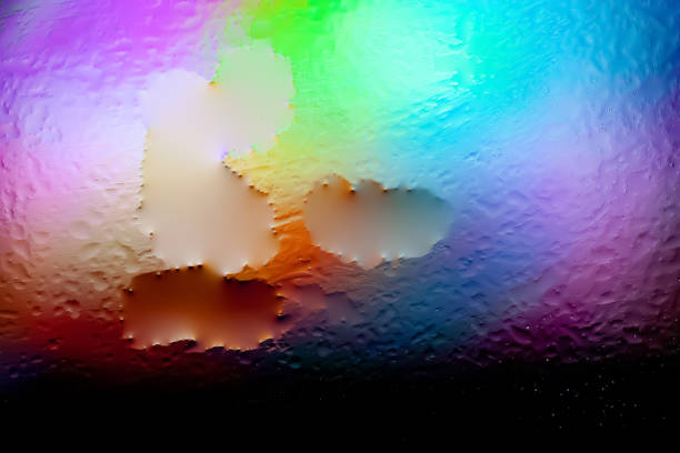 Abstract background. Abstract blur image of colored soft spots of gradients and glare through wet ice glass. Texture of water drops on frozen glass. Creative background