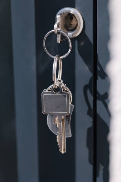 istock Keyring with two silver keys hanging from a door lock, modern handle in focus. 2188074379