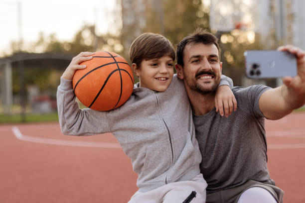 istock Basketball Fun: Father and Son Sharing a Selfie on the Court 2188082435