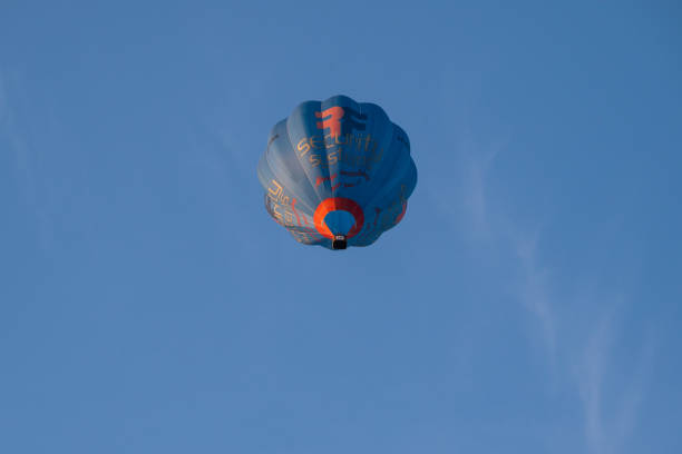 An image of the underside of a hot air balloon with white, red, and blue stripes. The sky in the background is a rich blue color.