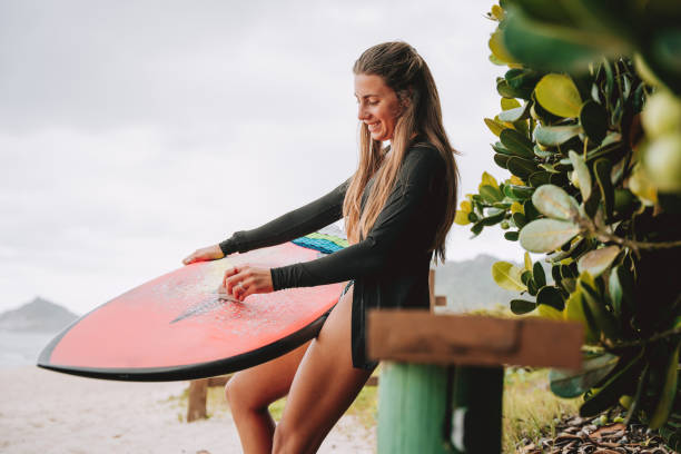 istock Woman applying wax to surfboard 2188084522
