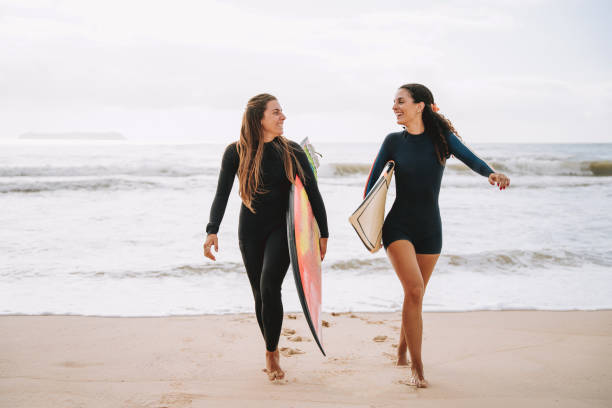 istock Two surfer friends running into the sea holding a surfboard 2188090649
