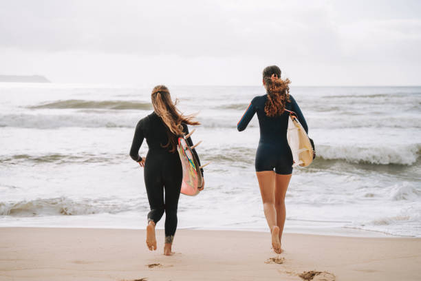 istock Two surfer friends going surfing in the sea 2188090667