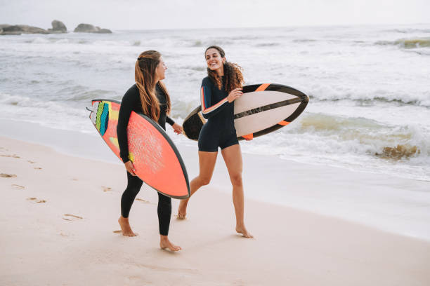 istock Two surfer friends running into the sea holding a surfboard 2188090705