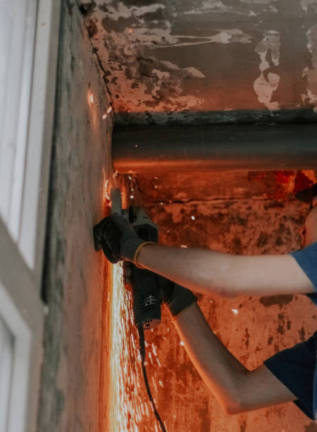 istock Young caucasian builder carpenter holds an angle grinder in his hands and cuts a stud from a wall 2188098364