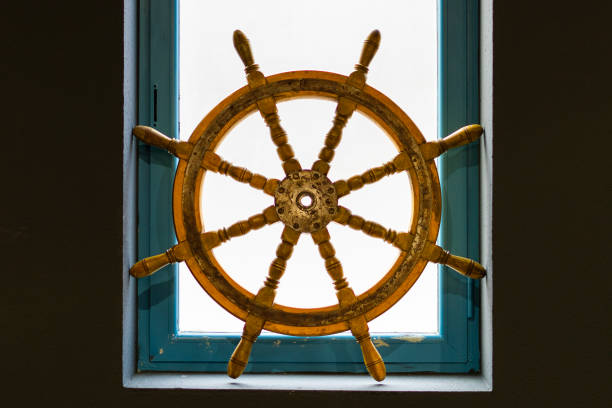 istock Vintage ship steering wheel in a blue window 2188098377